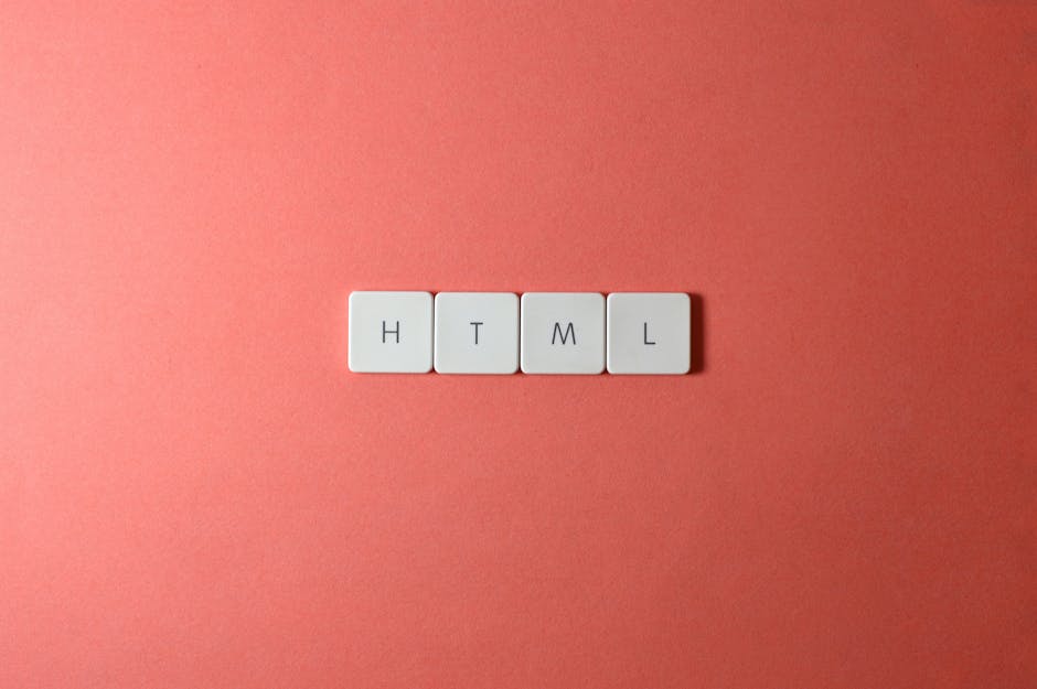 Four white rectangular tiles with black letters spelling 'HTML' are arranged in a horizontal line on a smooth, coral-colored background. The tiles are evenly spaced, and the lighting is soft, creating